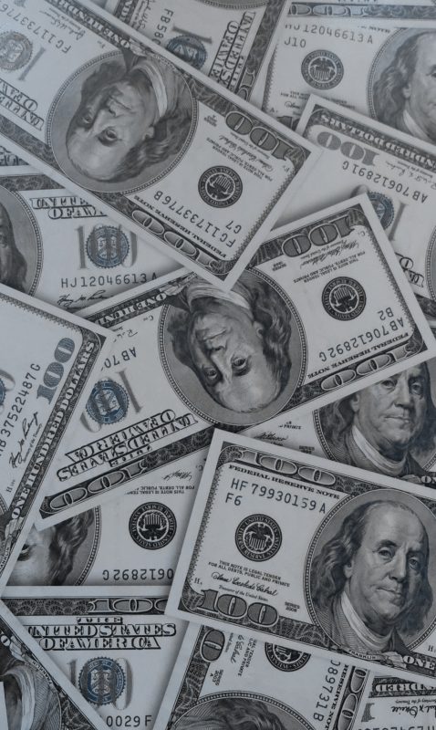 A pile of dollar bills scattered on the ground to depict the fintech industry.